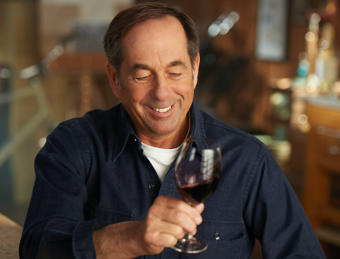 A man swirling wine in a glass