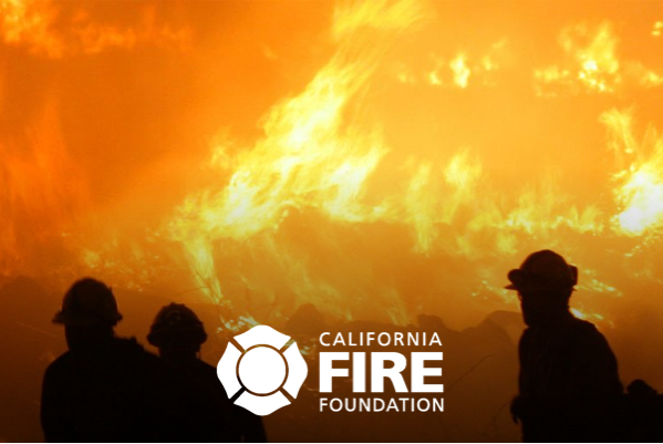 Firefights in front of a fire with the logo for California Fire Foundation
