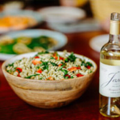 Picture of a Sun-dried Tomato & Pesto Pasta Salad next to a bottle of Josh wines