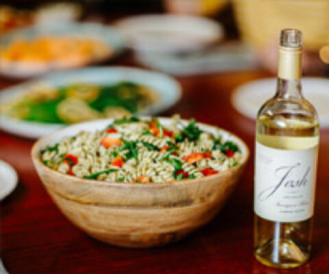 Picture of a Sun-dried Tomato & Pesto Pasta Salad next to a bottle of Josh wines